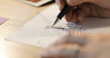 女孩在纸上画一支铅笔。 女时装设计师绘制草图.. 时装设计师绘图和油漆。 特写